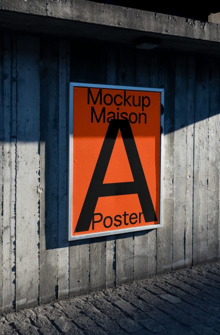 Orange poster with large black letter A mounted on weathered blue wood wall