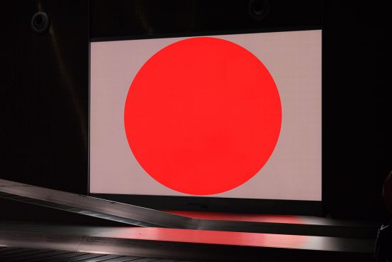 Large red circle graphic on digital billboard mockup for presentation, sleek design, modern advertising display in a dark setting.