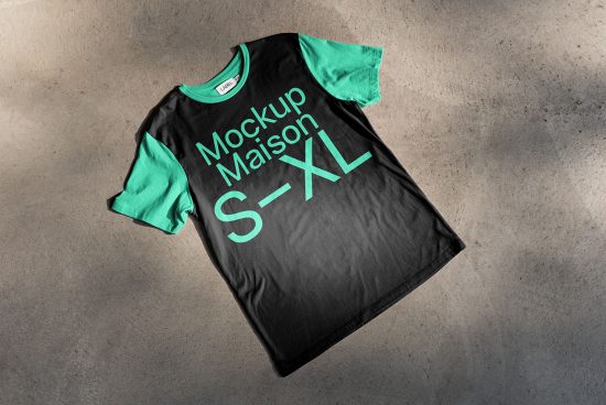 Black t-shirt mockup with teal graphic text on concrete background, editable PSD for fashion designers, apparel presentation.