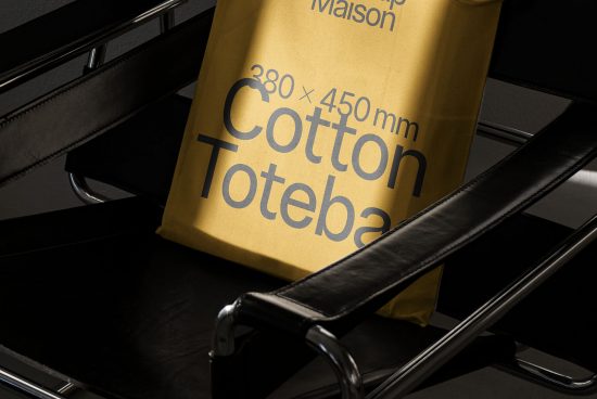 Yellow cotton tote bag mockup on black chair, modern design, high quality, realistic texture, stylish fonts, graphic designers asset.