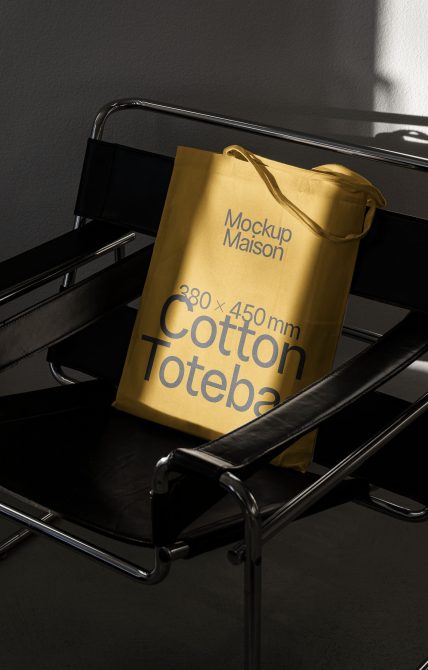 Gold cotton tote bag on black tray with rope handles, studio setup