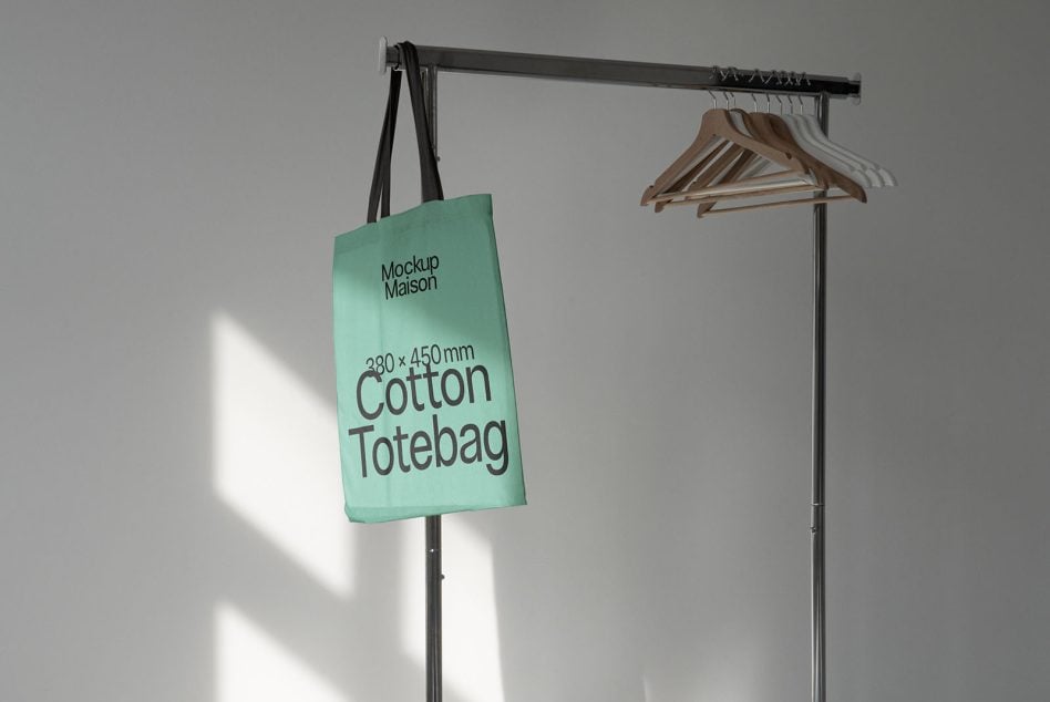 Mint tote on rolling rack next to wood hangers in bright sunlight