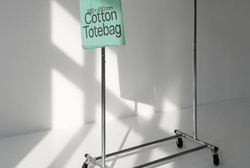 Tote bag mockup on metal stand in bright studio light, minimalist design presentation, high-quality visual for product branding.