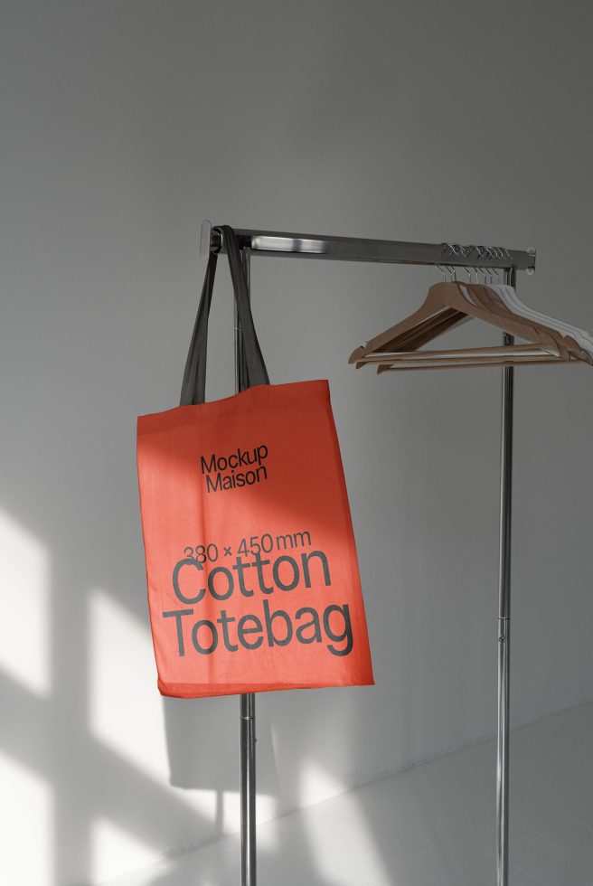 Elegant tote bag mockup on a coat rack, showing size dimensions with shadow play, ideal for showcasing design templates.