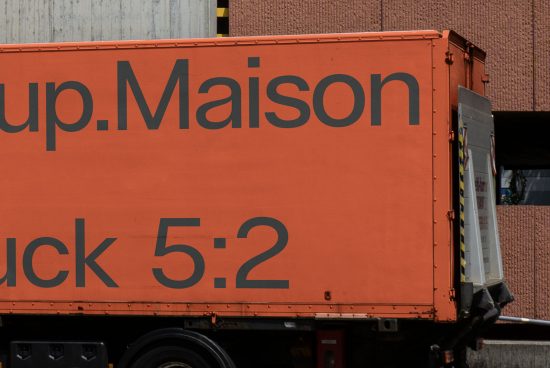 Side view of an orange delivery truck showcasing bold typography design, suitable for mockup and graphics inspiration.