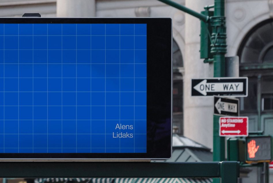Bright blue grid screen on street pole with traffic signs beside