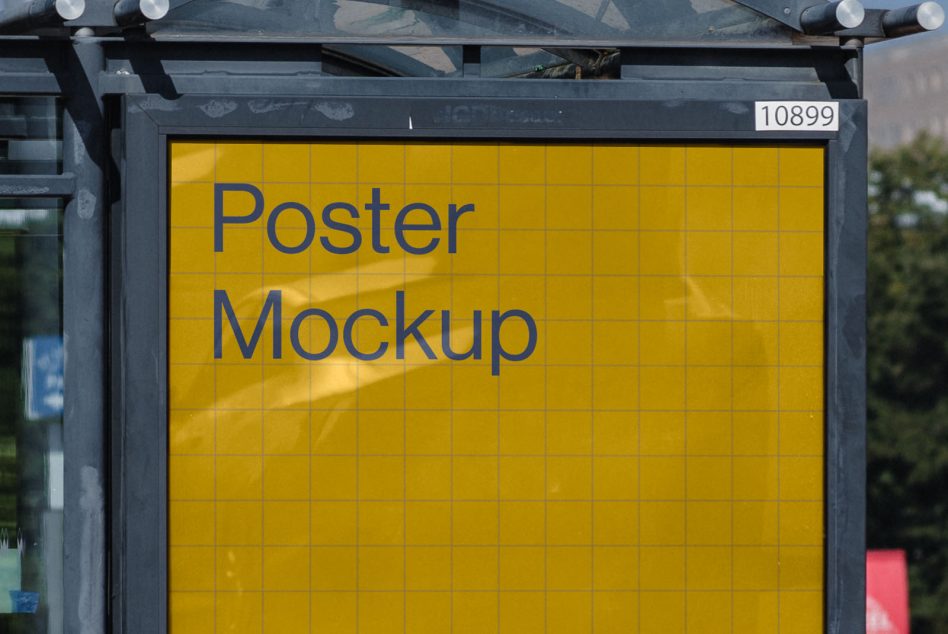 Yellow bus shelter poster with blue text on street