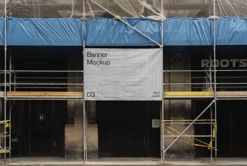 Urban street-level banner mockup hanging on scaffolding, offering realistic setting for graphic design presentations and advertising.