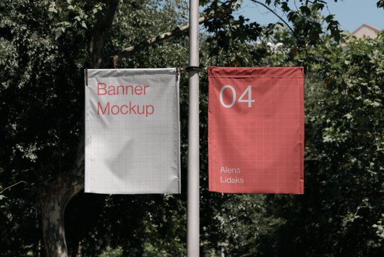 Two vertical outdoor banner mockups hanging on a lamp post with a natural tree and foliage background, ideal for branding presentations.