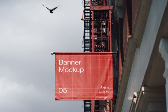 Urban outdoor banner mockup on building facade with fire escape ladder, red design, clear sky, and flying bird, for graphic designers.