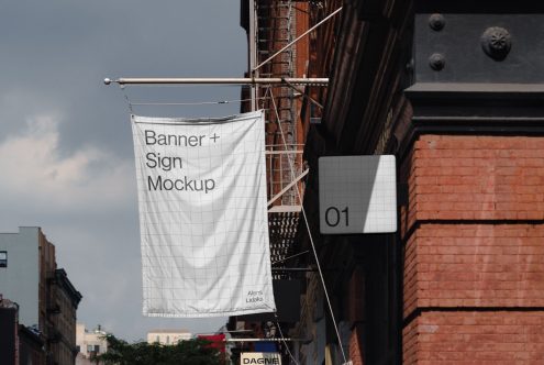 Banner and Sign Mockup hanging on a building's facade, suitable for showcasing design work to clients in urban outdoor settings.