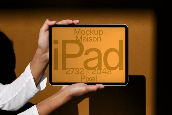 Person holding iPad digital mockup with editable screen against a dark background, ideal for showcasing app and web designs.