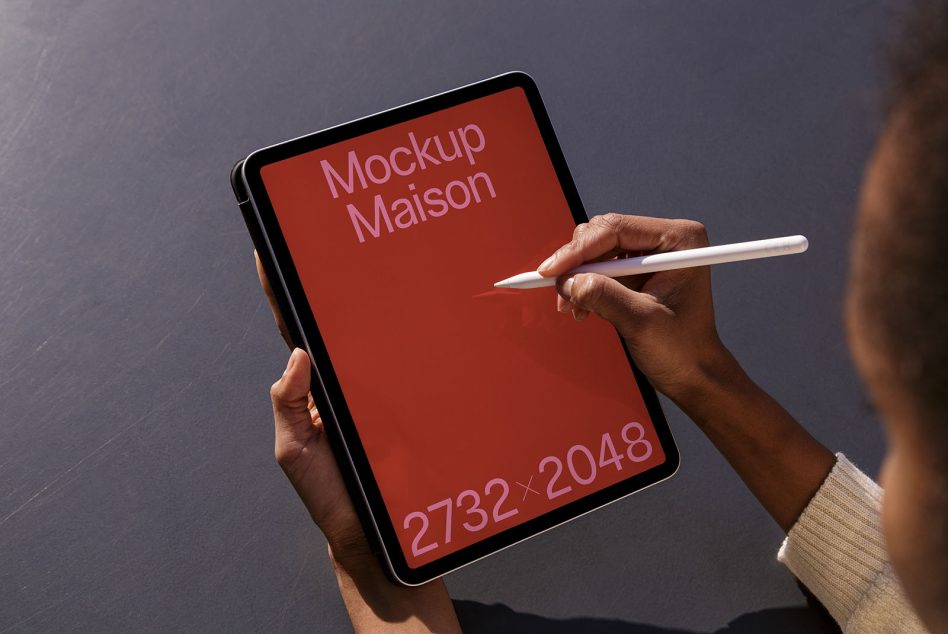 Person holding tablet with stylus, orange red screen showing dimensions, portrait orientation