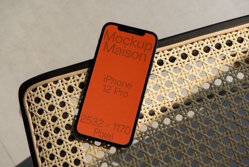 Responsive iPhone 12 Pro Mockup on a rattan surface for design presentation, showcasing screen resolution and mobile app display.