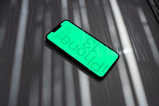 Smartphone mockup with unique shadows for showcasing app designs, lying on a textured surface, perfect for designers' presentations.
