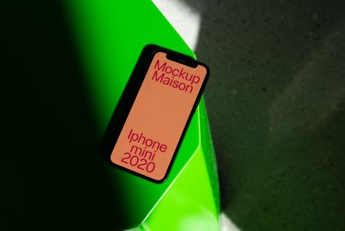 Smartphone mockup on green surface, dynamic shadows, digital assets for app design presentation, iPhone mini 2020, creative mockups for designers.