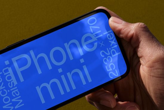 Hand holding smartphone mockup with blue screen displaying text and resolution, ideal for app design presentations, on yellow background.