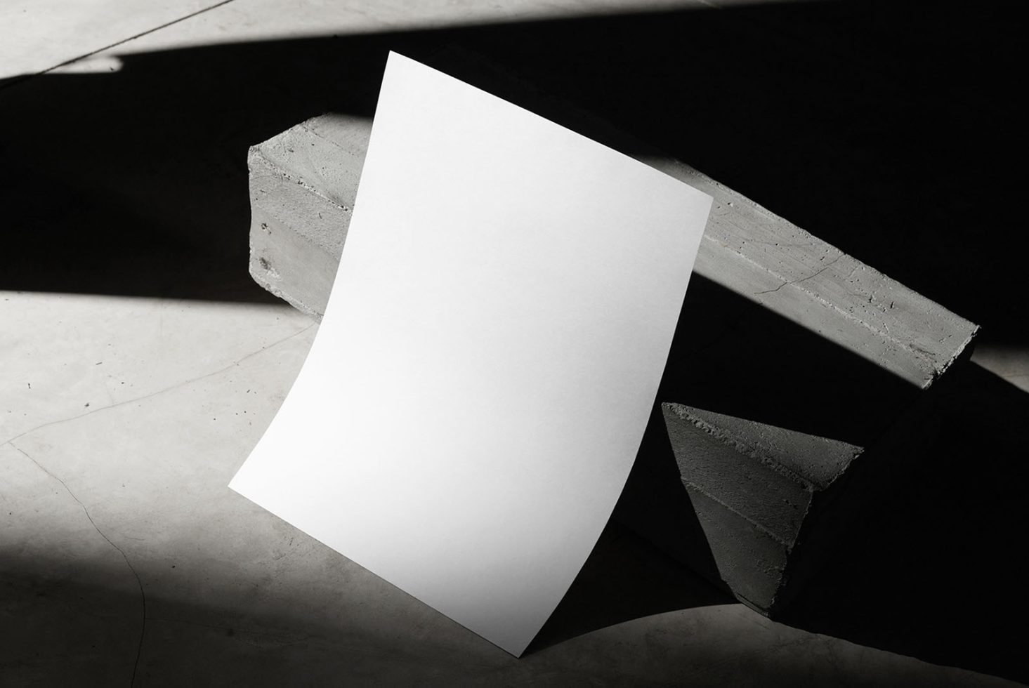 Blank A4 paper mockup with dynamic shadows on a concrete surface, ideal for showcasing stationery designs or typography.