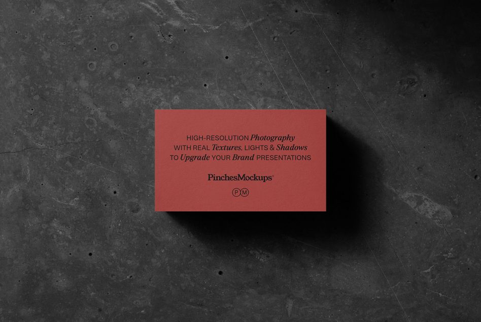 Coral business card mockup with realistic shadow on dark concrete background texture