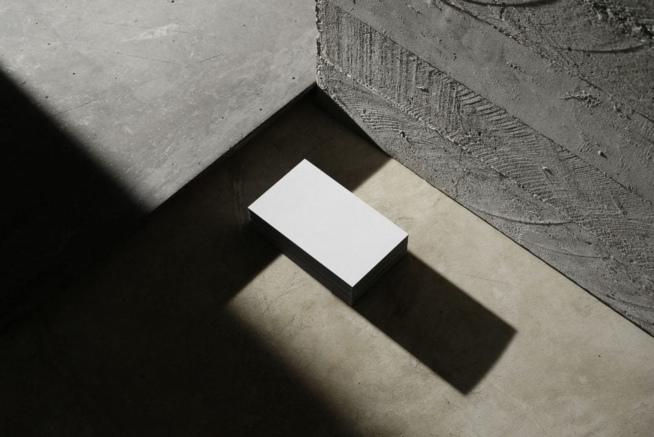 Business card stack on concrete with dramatic shadow from window light