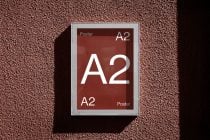 A2 poster mockup with silver frame on textured burgundy background with shadow