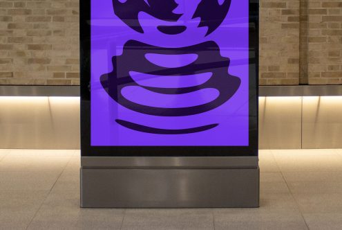 Digital display mockup in a modern lobby with abstract purple graphic, ideal for showcasing advertising designs or UI interfaces.