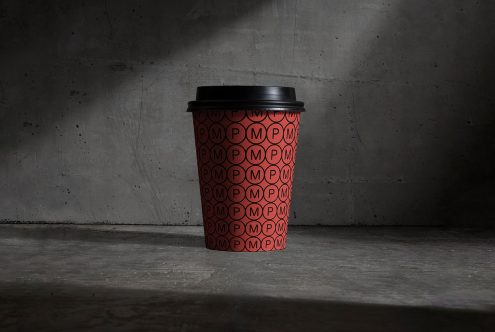 Disposable coffee cup mockup with red pattern design on concrete background, ideal for presenting branding projects for designers.