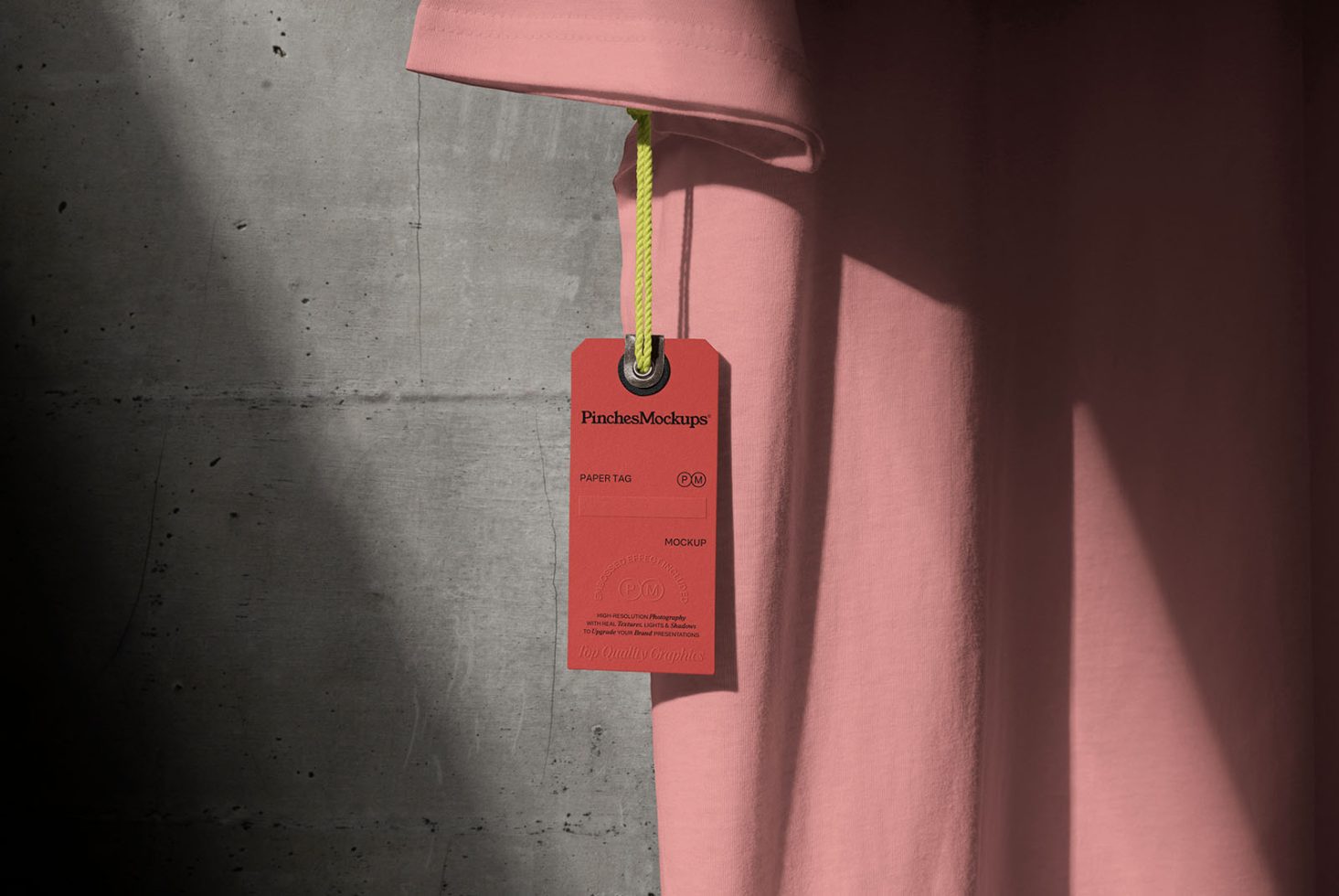 Elegant clothing tag mockup on pink t-shirt with concrete background, showcasing branding design with realistic shadows for graphic designers.