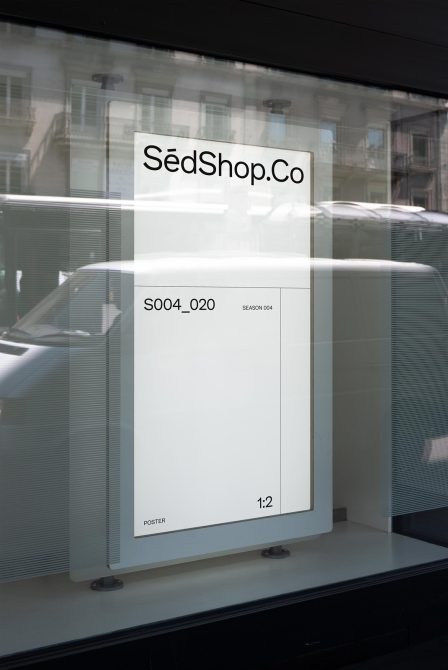 White poster mockup in shop window displaying SédShop.Co branding in 1:2 ratio