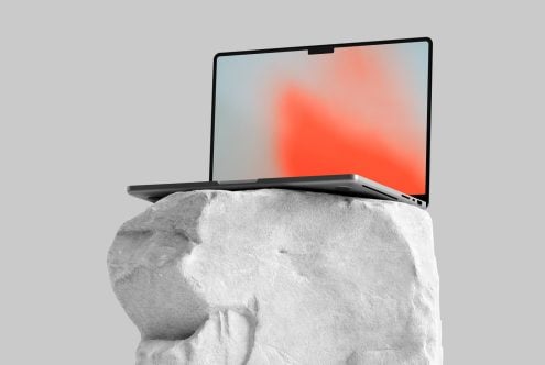 Laptop on marble bust showing coral orange gradient wallpaper