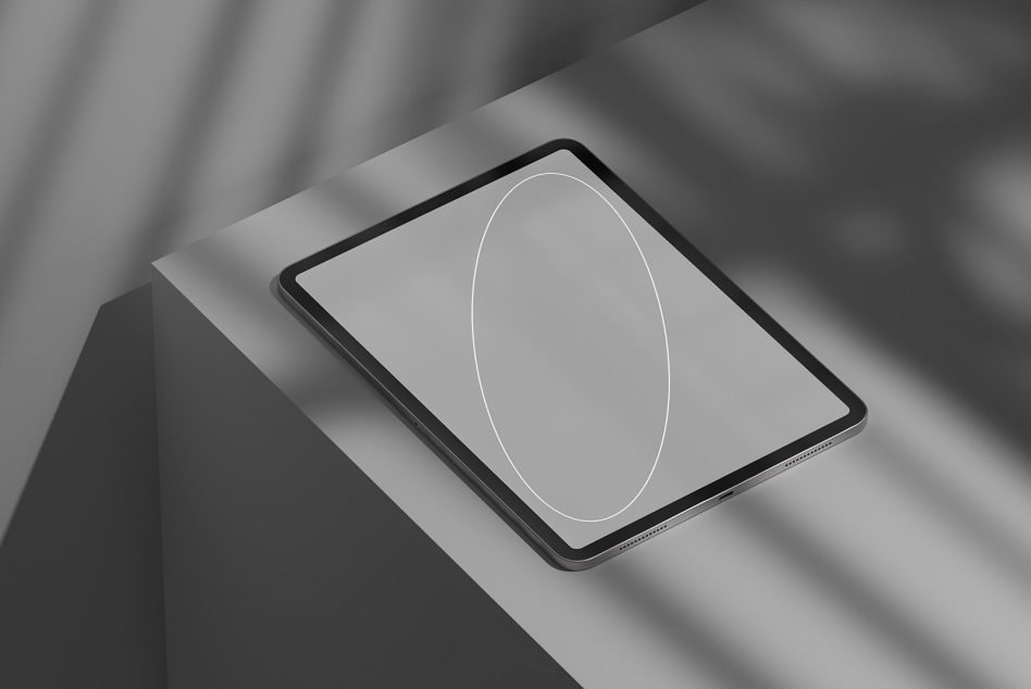 Tablet lying flat with neutral grey display, white curved line design