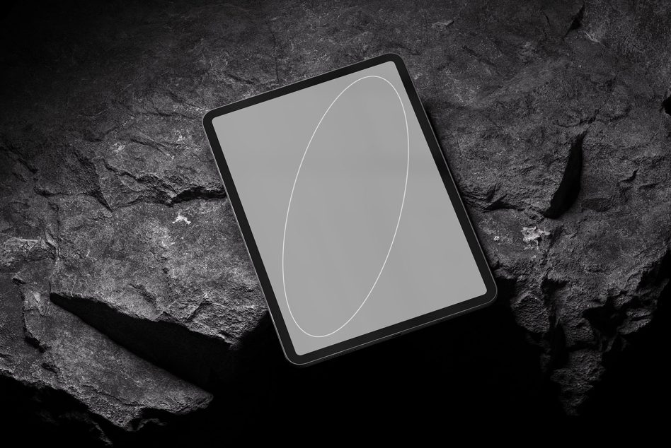 Tablet mockup on dark rocky surface with minimal line design on screen
