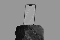 Phone mockup on stone surface with clean gray screen layout
