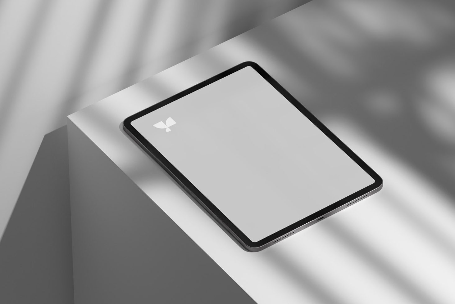 Tablet on white surface casting soft shadow in bright light