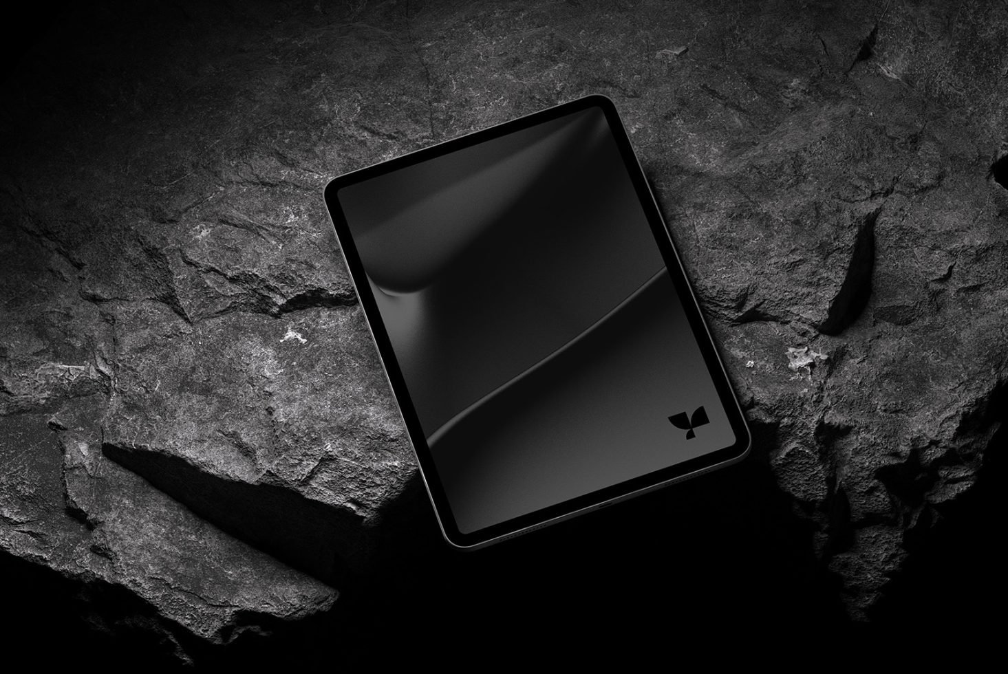 Sleek tablet mockup on a textured dark rock surface, ideal for showcasing app designs and digital art with a modern, edgy look for designers.
