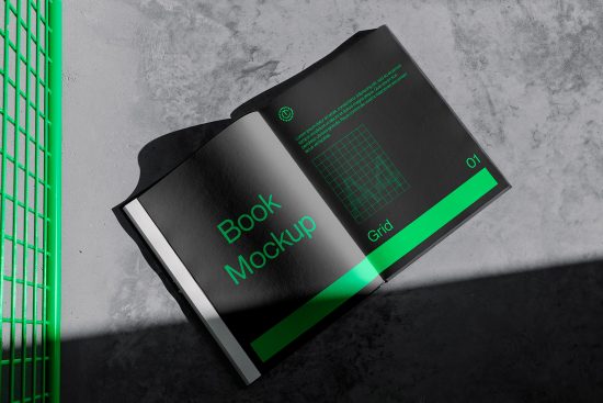 Elegant book mockup open on concrete surface with green design elements, ideal for showcasing graphic design works and book layouts.