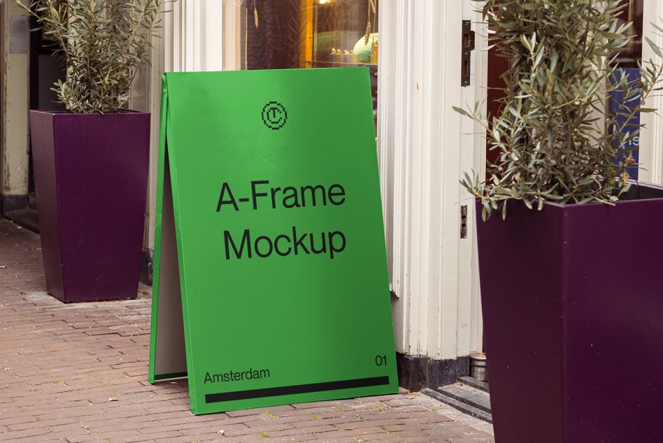 Bright green A-frame sign on sidewalk with potted olive plants beside storefront