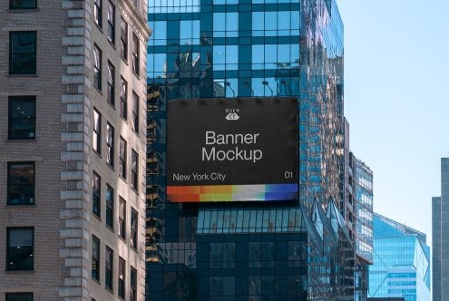 Black urban billboard between brick towers with colorful gradient stripe