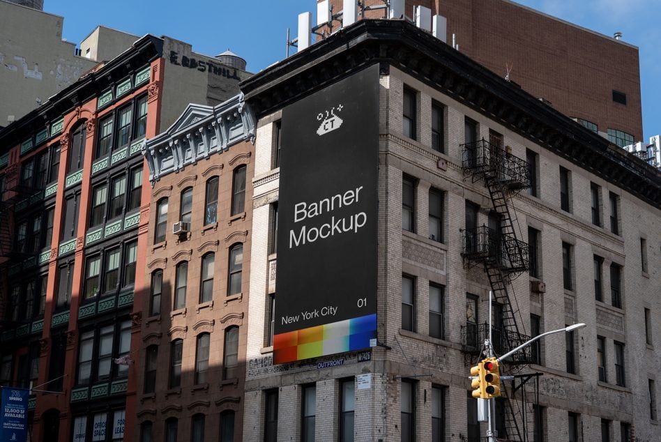 Large dark banner on historic building with rainbow stripe at base