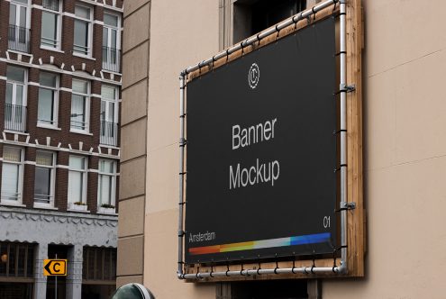 Large fabric banner mockup hanging on building facade with colorbar design