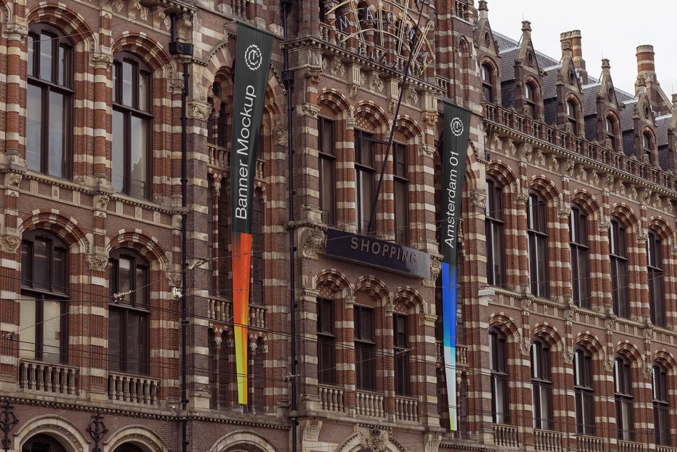 Two tall hanging banners on ornate brick building with colorful gradient stripes