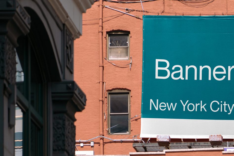 Teal banner with white text on red brick building facade