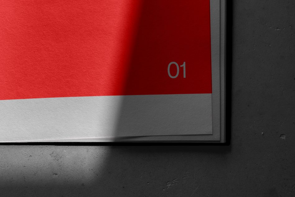 Red magazine spread with gray number 01 on dark surface