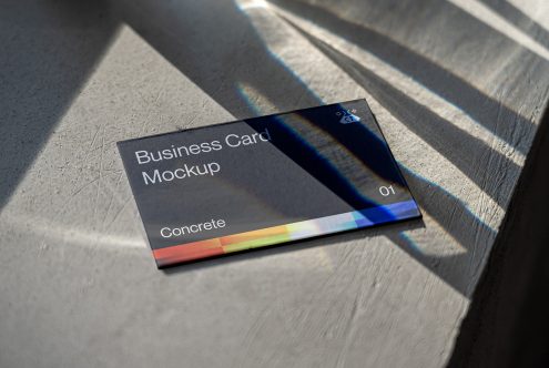 Dark business card with colorful stripe on wood in natural sunlight with prism effects