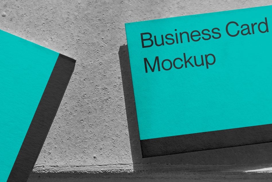 Turquoise business card mockup against concrete floor surface