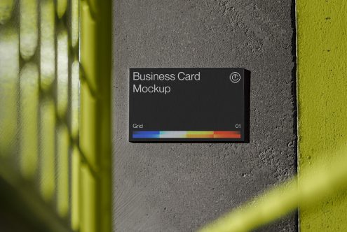 Black business card with rainbow stripe on concrete, neon yellow edge