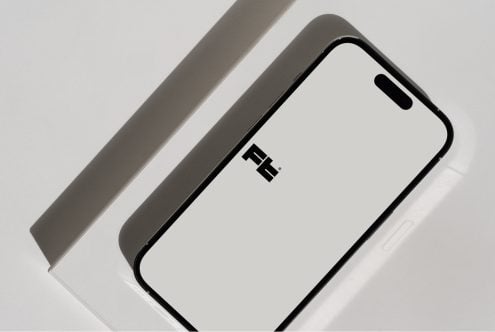 iPhone 14 Pro mockup at angle on white backdrop with gray paper strip