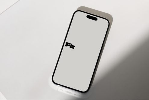iPhone 14 Pro mockup with blank screen, angled overhead view on white surface