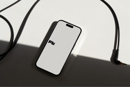Phone mockup with 3.5mm jack headphones in moody studio lighting