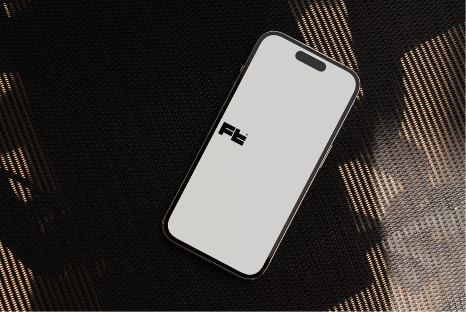 Black phone mockup on dark fabric with golden geometric light pattern backdrop